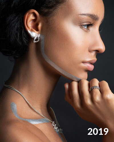 Photo de profil d'une femme qui porte des bijoux de créateur. 